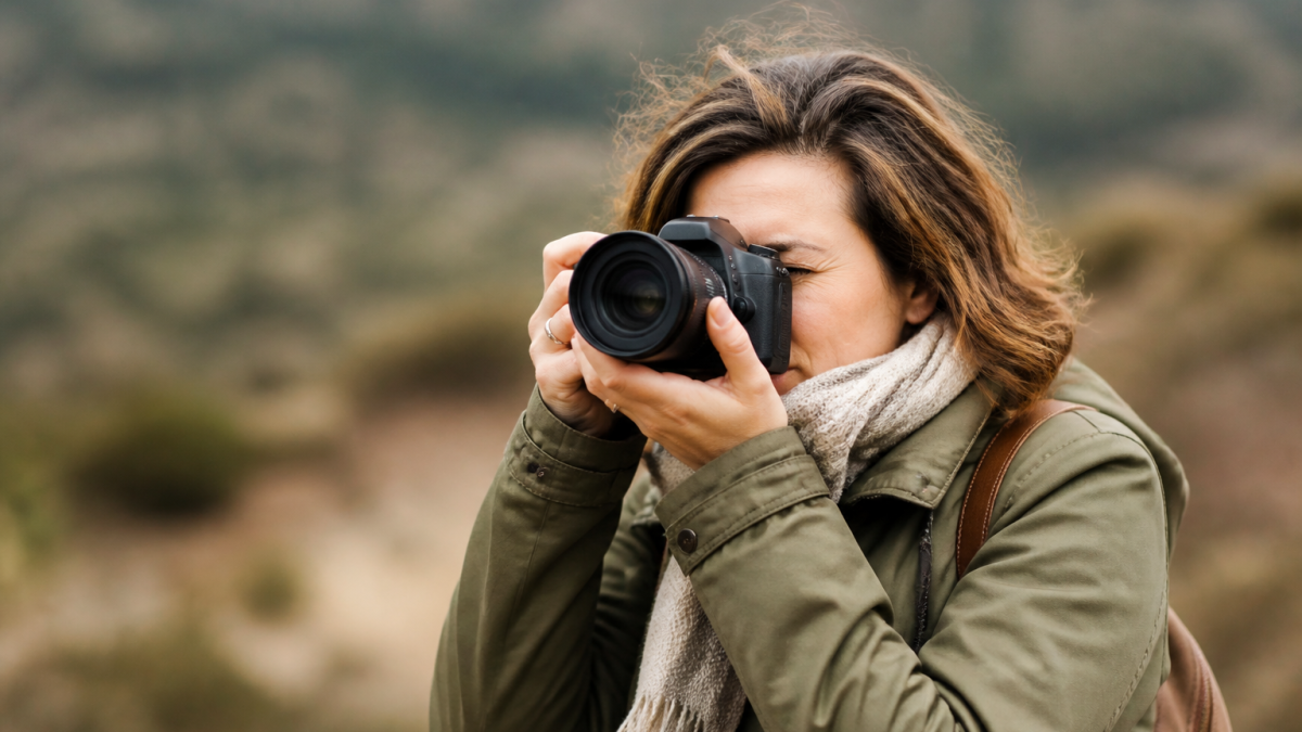 Photographe tenant appareil photo, arriere plan flou et defocalise
