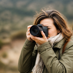 Photographe tenant appareil photo, arriere plan flou et defocalise