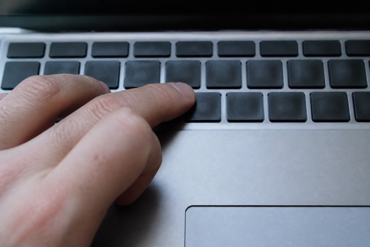 Doigts appuyant sur touches Option et E clavier Mac