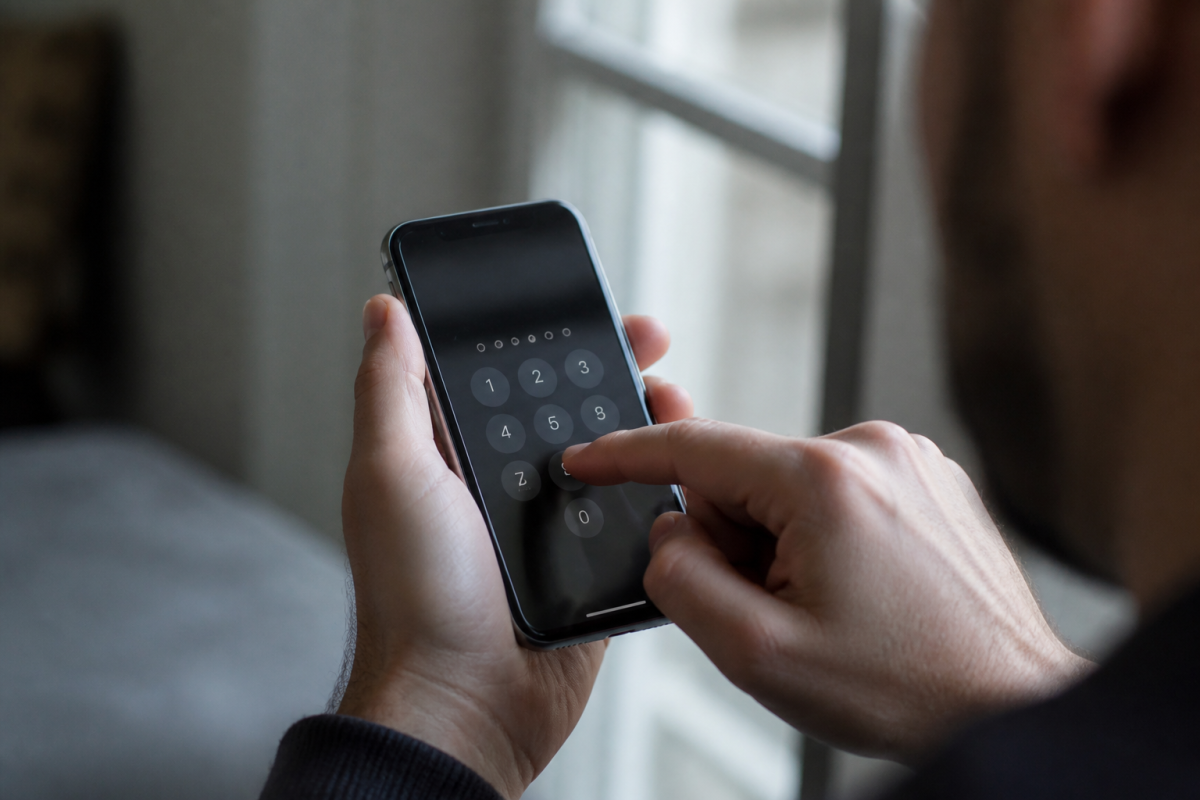 Doigt appuyant sur clavier numerique iPhone pour creer code securite
