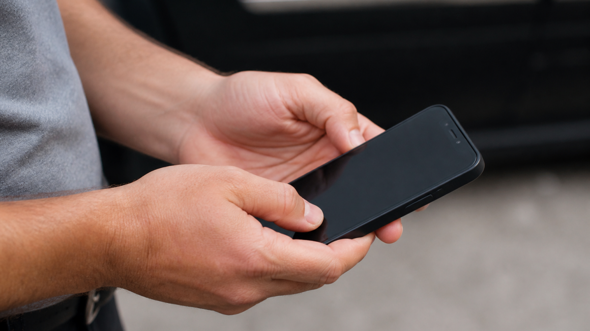 Main appuyant sur boutons physiques smartphone ecran noir inactif
