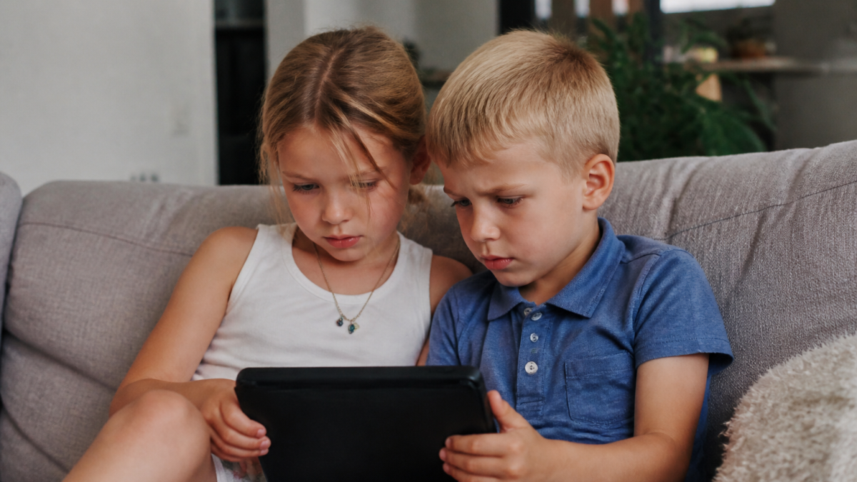 Enfants assis regardant écran noir brillant ensemble