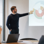 Formateur debout presentant diagramme impact sur ecran projete