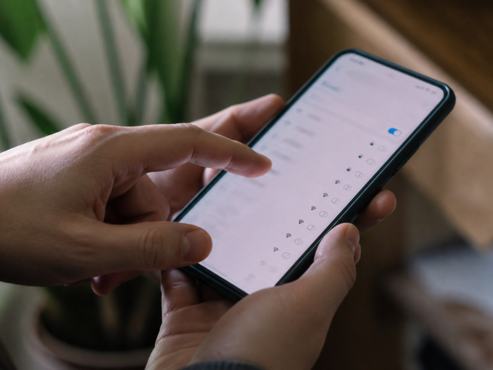 Doigt appuyant sur ecran smartphone affichant parametres reseau wifi