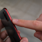Doigt appuyant sur bouton reinitialisation telephone android rouge
