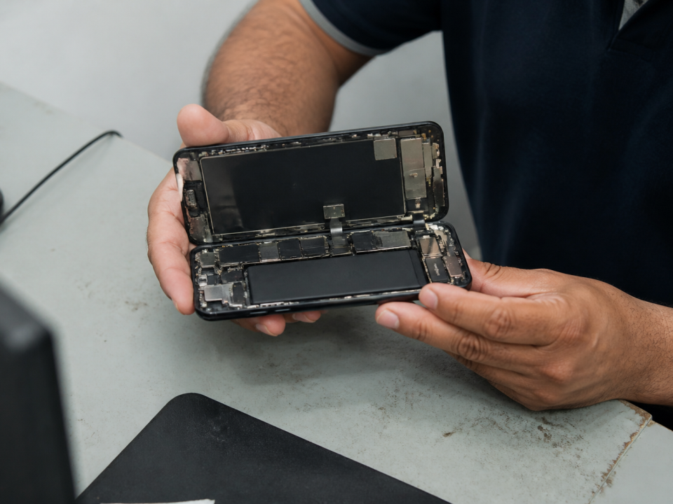 Technicien tenant iPhone 11 ouvert horizontalement, batterie visible