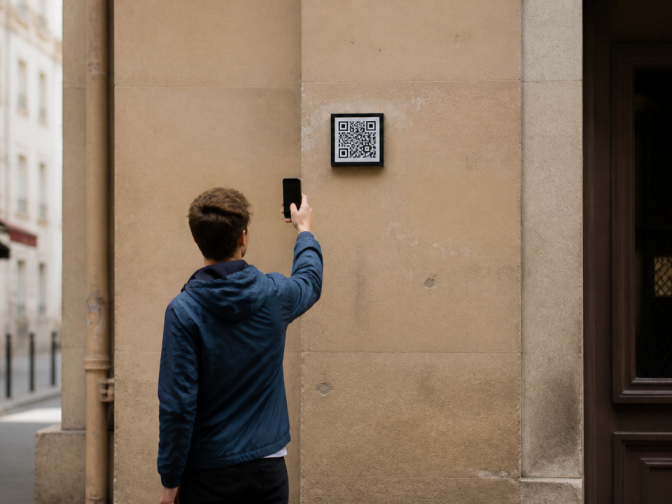 Main tenant telephone face camera vers code barres carre