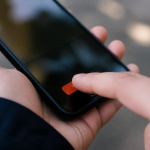 Doigt appuyant sur bouton suppression rouge sur ecran smartphone