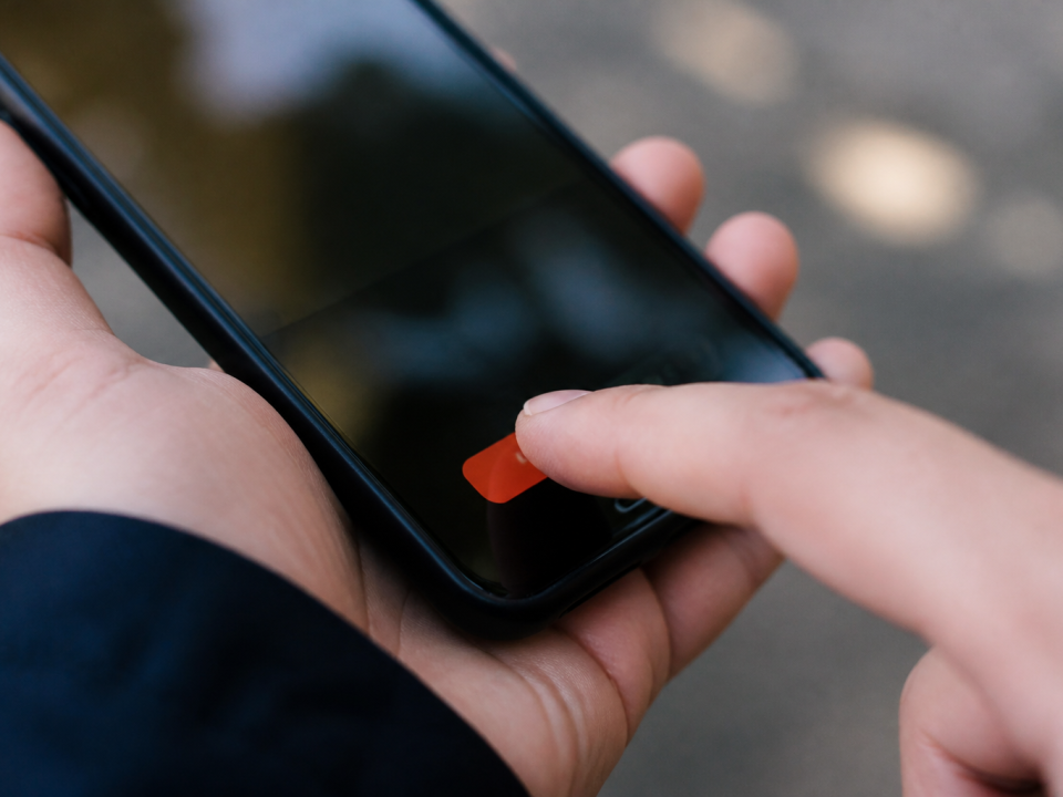 Doigt appuyant sur bouton suppression rouge sur ecran smartphone