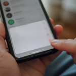 Doigt appuyant sur contact WhatsApp avec option suppression affichee