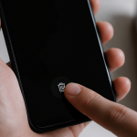 Doigt appuyant sur icone corbeille smartphone ecran noir