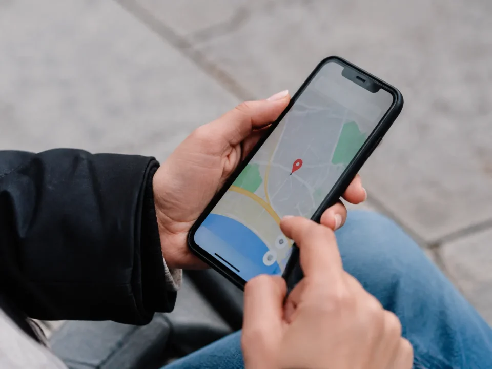 Main tenant smartphone affichant carte avec repere rouge