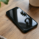 Main tenant smartphone pose sur table en bois
