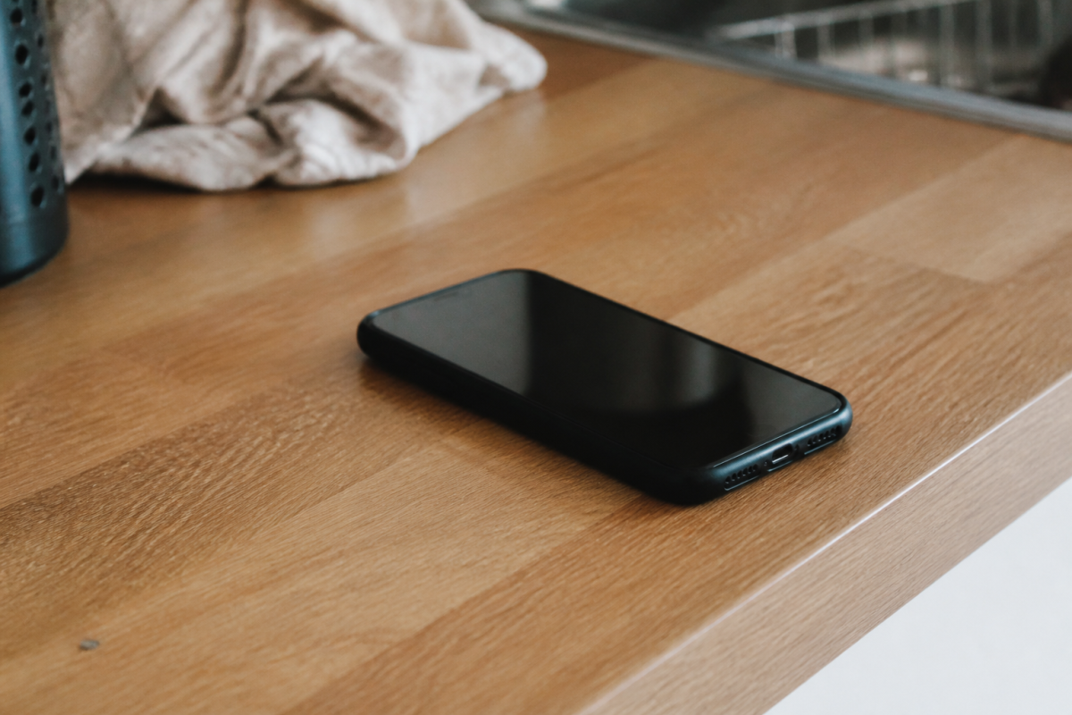 Smartphone noir reposant sur un comptoir en bois