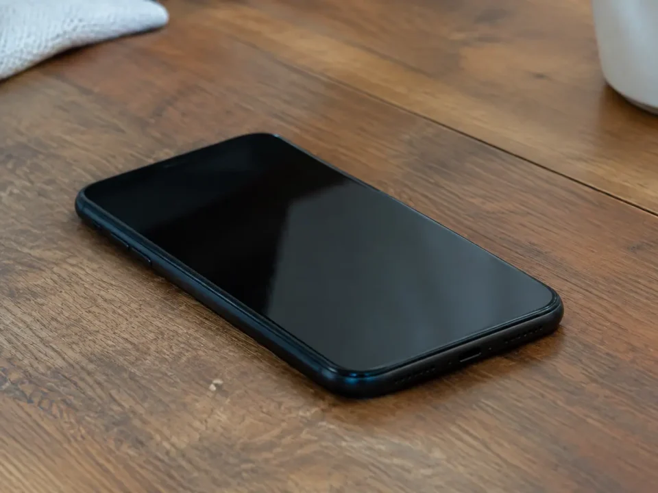 Smartphone noir pose a plat sur table en bois