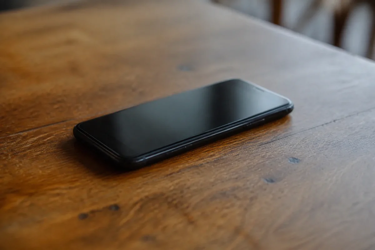Smartphone noir pose sur table en bois brune