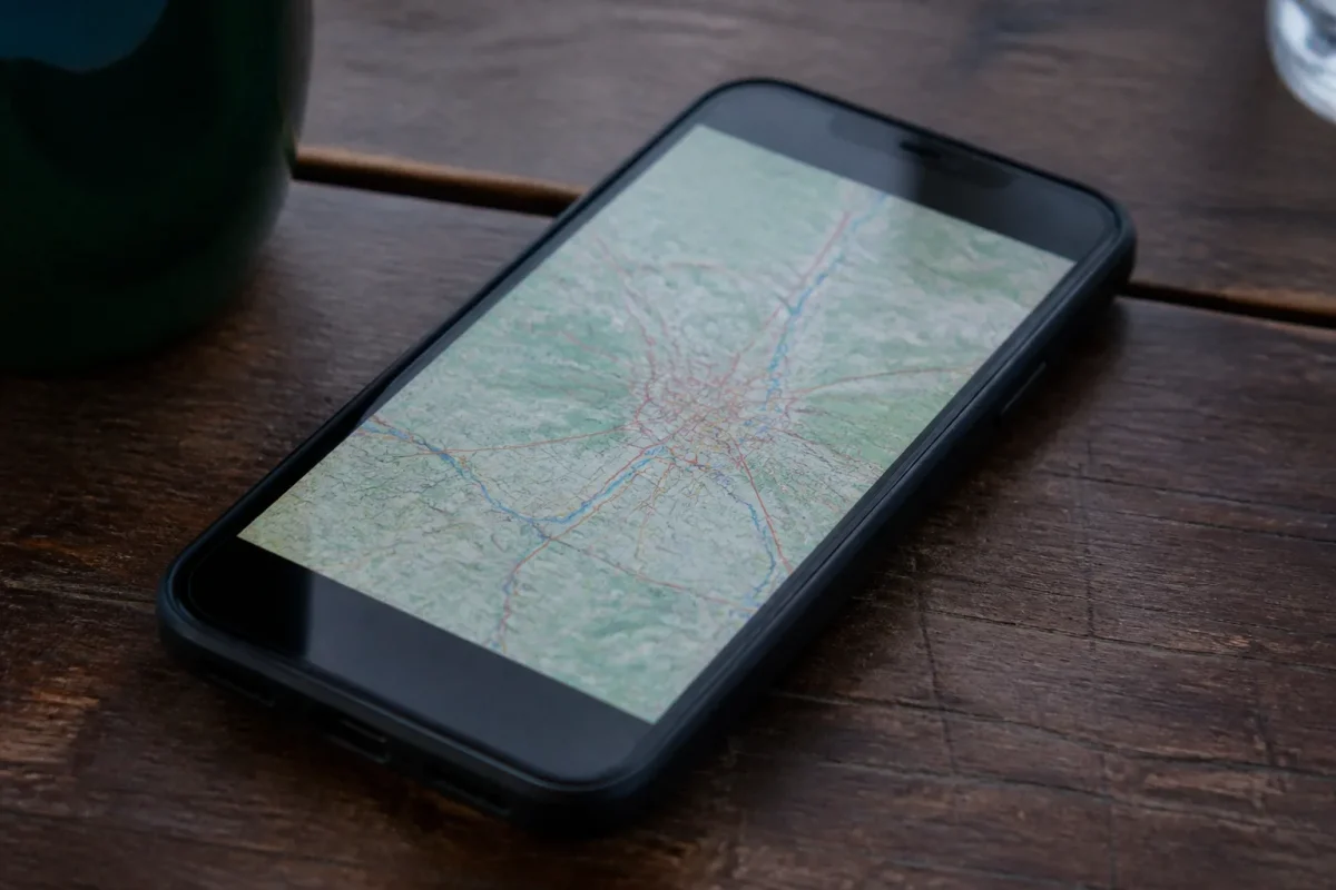 Smartphone noir sur table, carte affichee sur ecran