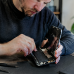 Technicien tient smartphone ouvert pour remplacer accu